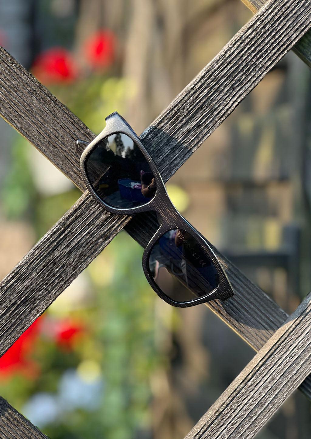 Our handmade wayfarer wooden sunglasses called Obsidian Shade. Photo taken out in the Swedish summer.