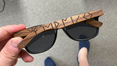 Engraved wooden sunglasses with accessories.