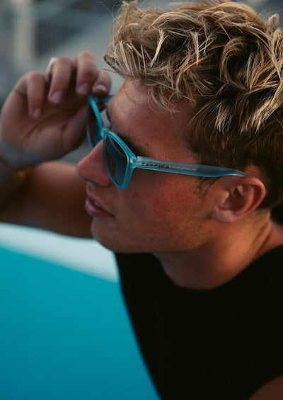 Our Mood V2 is an improved version of our last wayfarers. Plastic body for great quality and durabilty. This is Belize with blue frame and blue lenses. On male model.