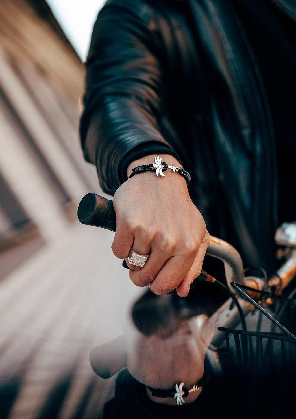 Starlight - Season two Palm anchor bracelet with black leather. On male model riding a motorcycle.