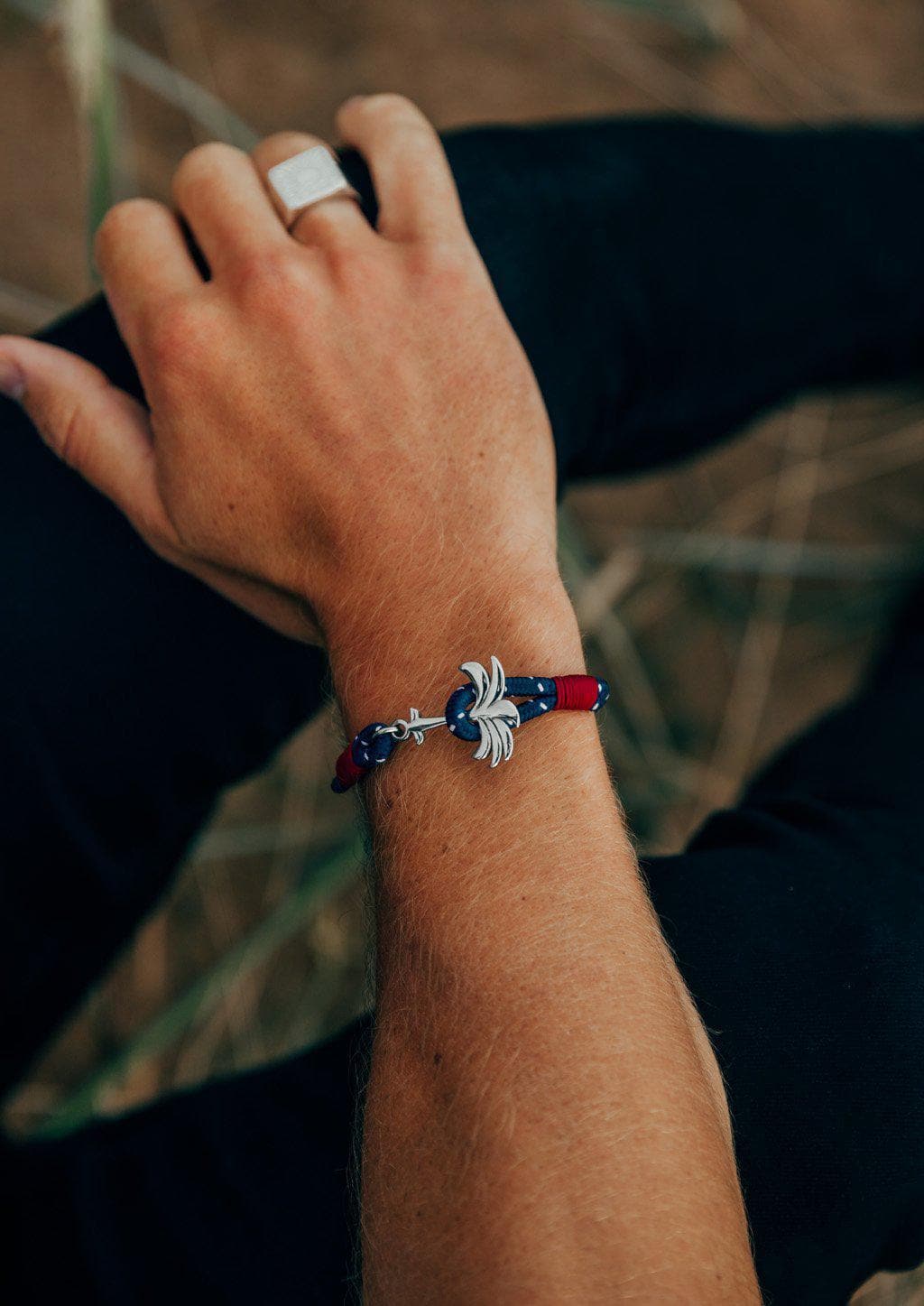 Voyager - Single - Season two Palm anchor bracelet with blue and red nylon band. Tanned arm.