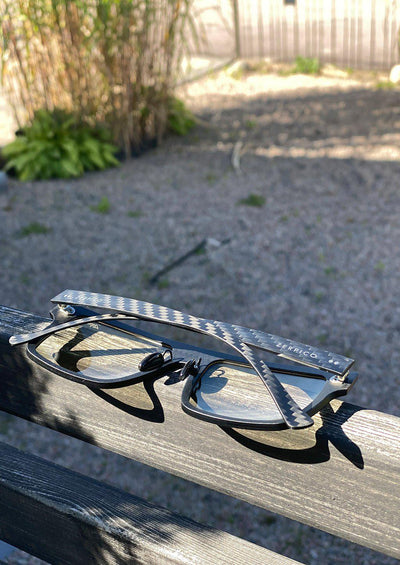 Our Anti Blue Light Square version of our Fibrous Carbon Fiber glasses. Perfect for gamers. Also turns dark outside. Photo taken outside to show the carbon fiber.