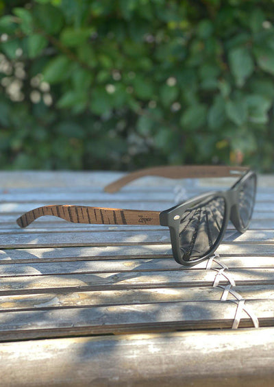 Engraved wooden sunglasses inspired by the untamed tigers and lions. Photo taken outside in the Swedish summer showing the full spread of the design.