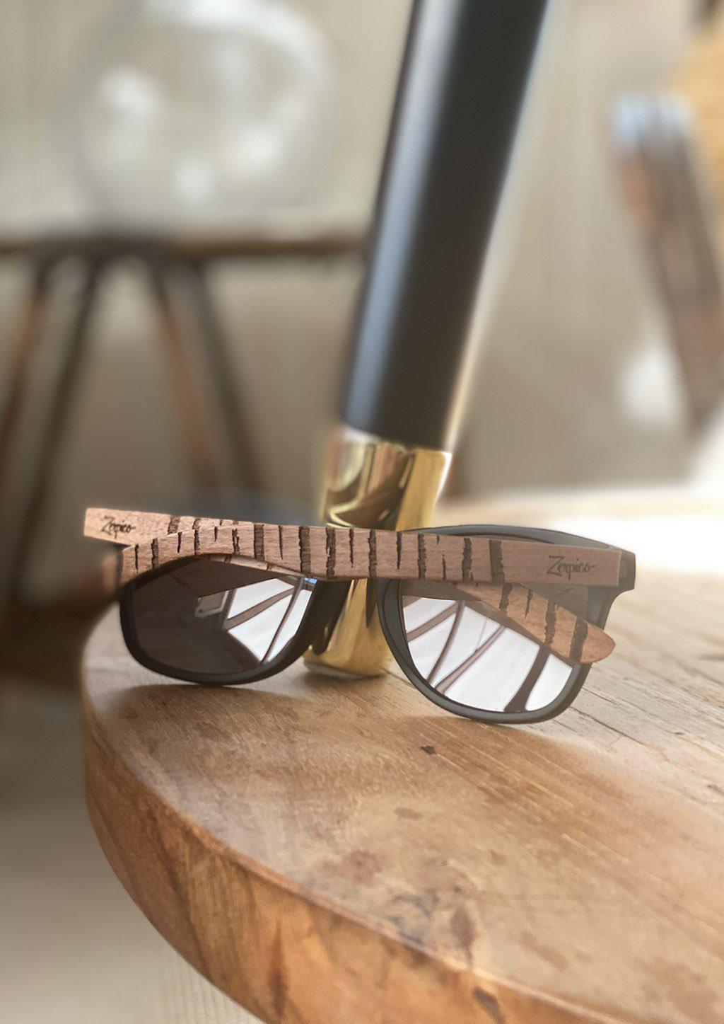 Engraved wooden sunglasses inspired by the untamed tigers and lions. Lifestyle photo taken inside.