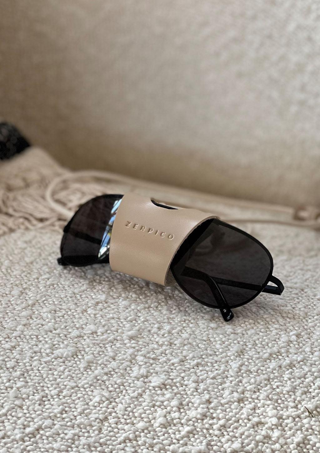 Lifestyle photo of our beige leather sunglasses carrier.