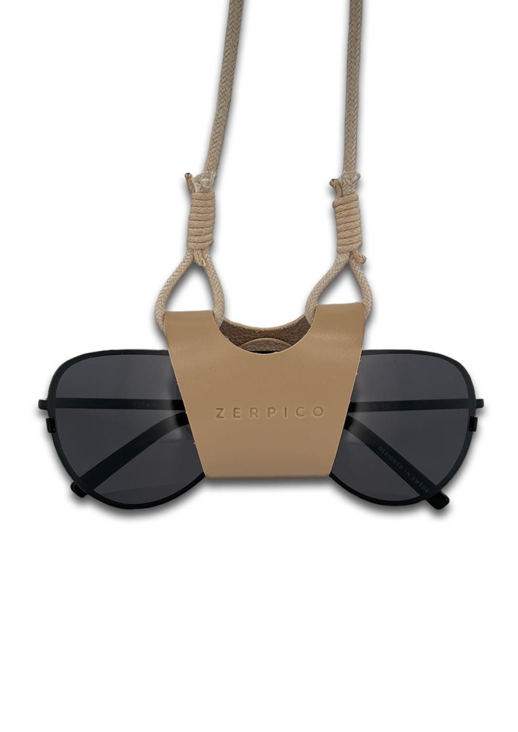 Sunglasses carrier that will keep your sunglasses around your neck. In beige leather.