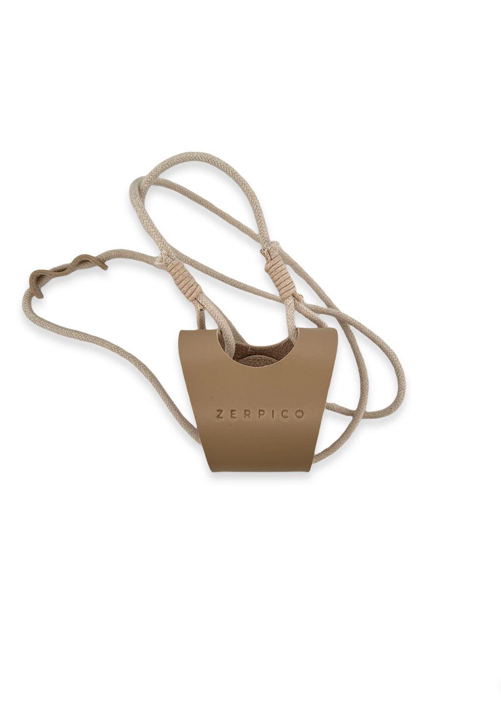 Studio photo of the beige leather sunglasses carrier.