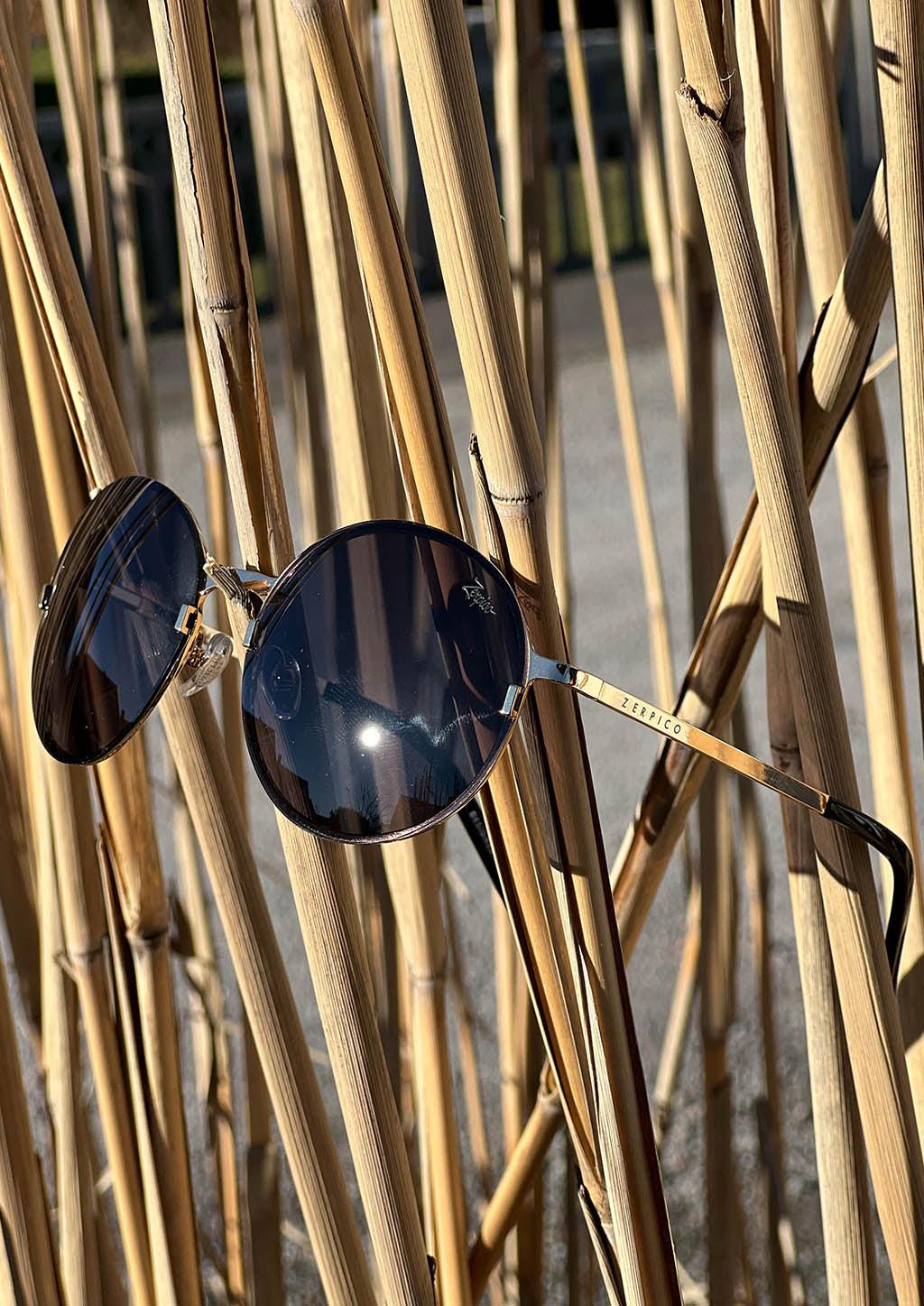 Titan - Titanium Round Sunglasses V2 - 24K Gold Plated with real gold. Photo taken outside with bamboo.