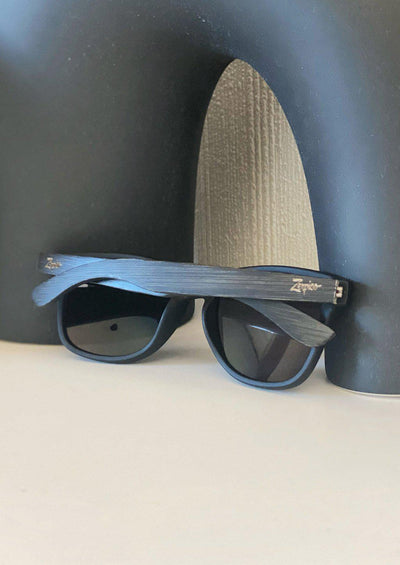 Handmade wooden wayfarers in wood and are guaranteed to give you a natural feeling of comfort and design.  Andariel is a walnut wooden model with black matte plastic front. This special edition pair is made to stand out. Lifestyle photo from the back.